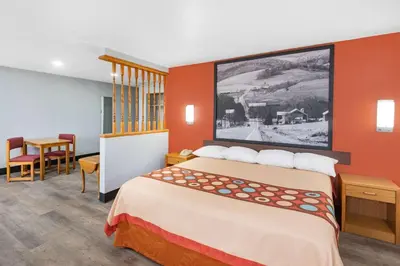 a hotel room with a bed and a table at Super 8 by Wyndham Waynesburg in Waynesburg