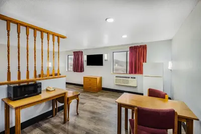 a living room with a table and a dining room at Super 8 by Wyndham Waynesburg in Waynesburg