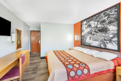 a hotel room with a bed and a tv at Super 8 by Wyndham Waynesburg in Waynesburg