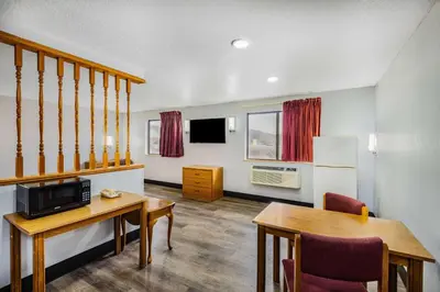 a living room with a table and a dining room at Super 8 by Wyndham Waynesburg in Waynesburg