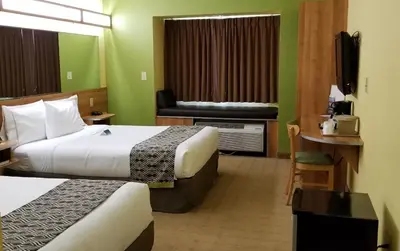 a hotel room with two beds and a television at Microtel Inn & Suites by Wyndham Delphos in Delphos
