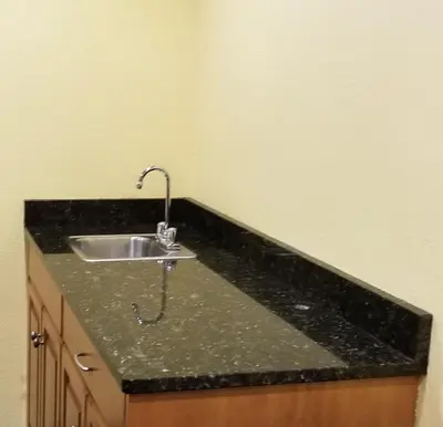 a kitchen sink with a black counter top at Microtel Inn & Suites by Wyndham Delphos in Delphos