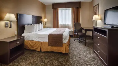 a hotel room with a bed and a flat screen tv at Best Western Elyria in Elyria