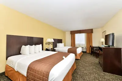 a hotel room with two beds and a flat screen tv at Best Western Elyria in Elyria