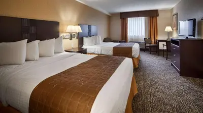 a hotel room with two beds and a television at Best Western Elyria in Elyria