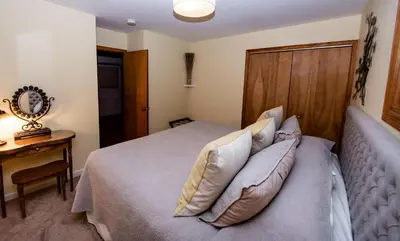 a bedroom with a bed with pillows and a wooden headboard at The Broadway Guest House in Granville