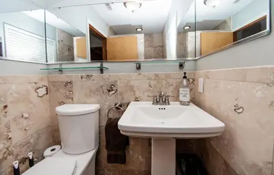 a bathroom with a sink and a toilet and a mirror at The Broadway Guest House in Granville