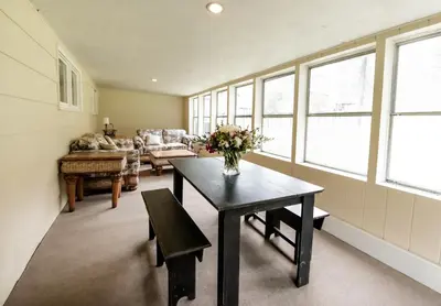 a living room with a table with a vase of flowers at The Broadway Guest House in Granville