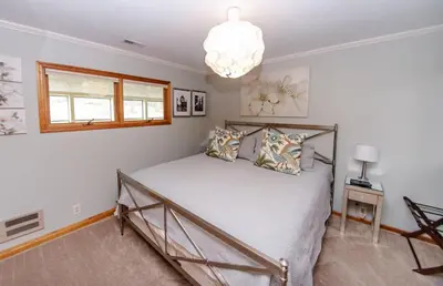 a bedroom with a bed and a chandelier at The Broadway Guest House in Granville