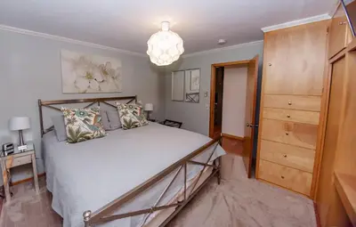 a bedroom with a large bed and a chandelier at The Broadway Guest House in Granville