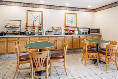 a kitchen with two tables and chairs and a counter at Ramada by Wyndham Strasburg Dover in Strasburg