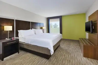 a bedroom with a large bed and a flat screen tv at Holiday Inn Express Chillicothe East by IHG in Chillicothe