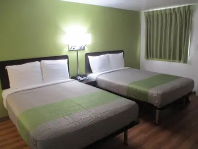 two beds in a hotel room with green walls at Motel 6-North Olmsted, OH - Cleveland in North Olmsted