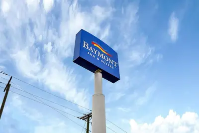 a blue sign on top of a pole at Baymont by Wyndham Zanesville in Zanesville