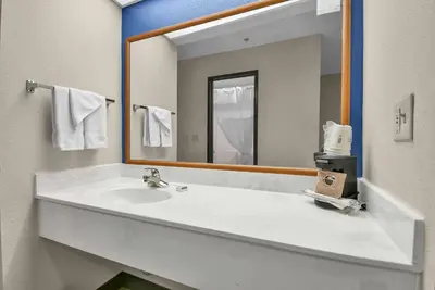 a bathroom with a sink and a large mirror at Baymont by Wyndham Zanesville in Zanesville