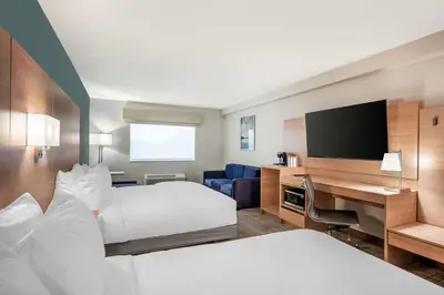 a hotel room with two beds and a desk with a television at Best Western River Cities in Ashland