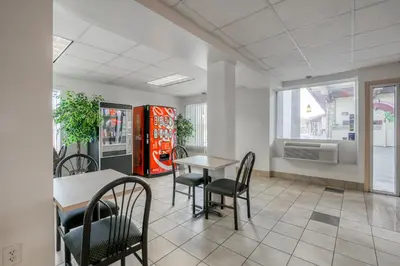 a restaurant with tables and chairs and a soda machine at FairBridge Inn Express North Lima in North Lima