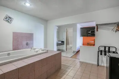 a large bathroom with a tub and a kitchen at FairBridge Inn Express North Lima in North Lima