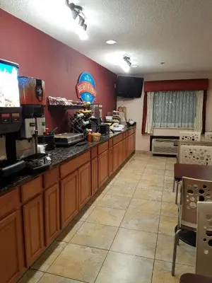 a kitchen with wooden cabinets and a counter top at Baymont by Wyndham Washington Court House in Jeffersonville