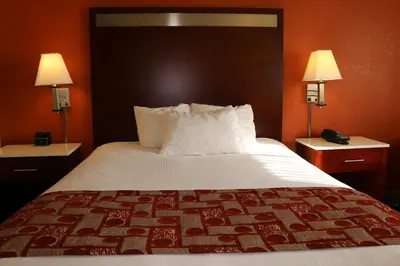 a bed in a hotel room with two lamps at Baymont by Wyndham Washington Court House in Jeffersonville