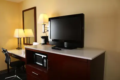 a flat screen tv on a dresser in a hotel room at Baymont by Wyndham Washington Court House in Jeffersonville