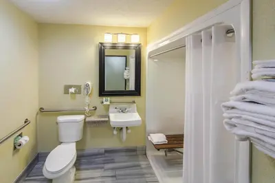 a bathroom with a toilet and a sink and a mirror at Quality Inn Decatur near US-224 in Decatur