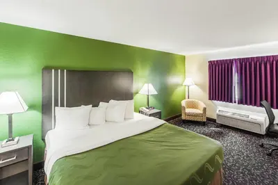 a large bed in a hotel room with green walls at Quality Inn Decatur near US-224 in Decatur