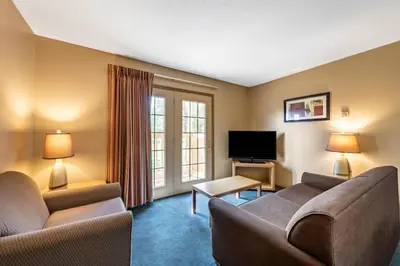 a living room with two couches and a flat screen tv at Americas Best Value Inn St. Marys in Saint Marys