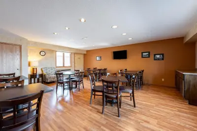 a dining room with tables and chairs and a tv at Americas Best Value Inn St. Marys in Saint Marys