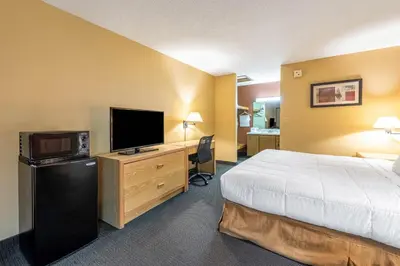 a hotel room with a bed and a flat screen tv at Americas Best Value Inn St. Marys in Saint Marys