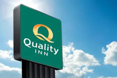a sign for a quality inn with a sky in the background at Quality Inn in New Martinsville