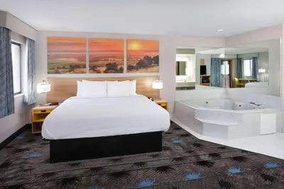 a hotel room with a bed and a bath tub at Days Inn by Wyndham Wooster in Wooster