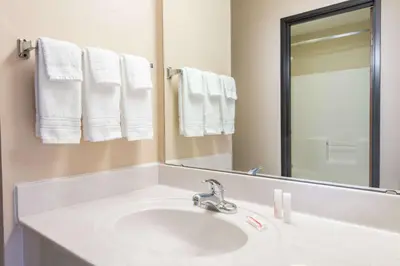 a bathroom with a sink and a mirror and towels at Days Inn by Wyndham Wooster in Wooster