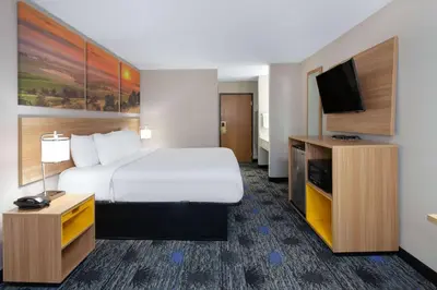 a hotel room with a bed and a flat screen tv at Days Inn by Wyndham Wooster in Wooster