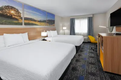 a hotel room with two beds and a flat screen tv at Days Inn by Wyndham Wooster in Wooster
