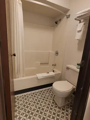a bathroom with a toilet and a tub and a sink at Super 8 by Wyndham Newcomerstown in Newcomerstown
