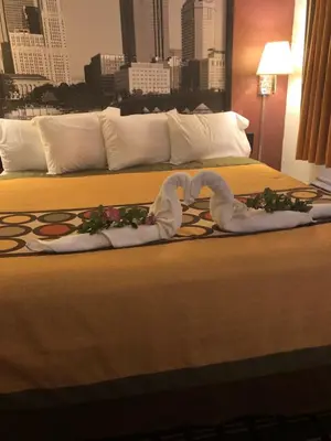 a hotel room with two beds with a heart made out of towels at Super 8 by Wyndham Newcomerstown in Newcomerstown