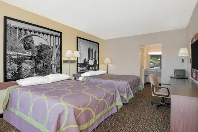 a hotel room with two beds and a desk at Super 8 by Wyndham Ashland in Ashland