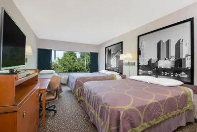 a hotel room with two beds and a flat screen tv at Super 8 by Wyndham Ashland in Ashland