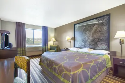 a hotel room with a bed and a television at Super 8 by Wyndham Weston WV in Weston