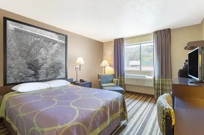 a hotel room with a bed and a television at Super 8 by Wyndham Weston WV in Weston