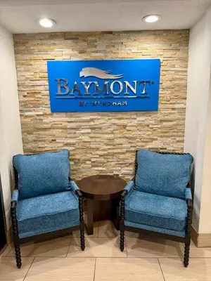 two chairs and a table in a room with a sign at Baymont by Wyndham Findlay in Findlay