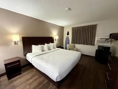 a hotel room with a large bed with white sheets at Baymont by Wyndham Findlay in Findlay