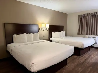 two beds in a hotel room with white sheets at Baymont by Wyndham Findlay in Findlay