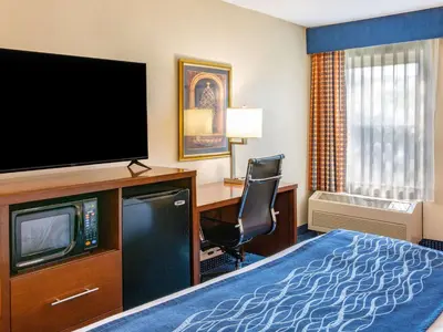 a hotel room with a bed and a flat screen tv at Comfort Inn Piketon near Fairgrounds in Piketon