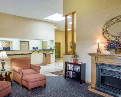 a living room with a fireplace and a chair at Comfort Inn Piketon near Fairgrounds in Piketon