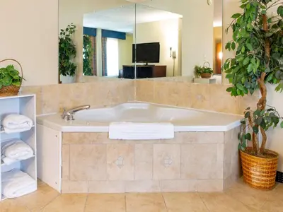 a bathroom with a bath tub with a large mirror at Comfort Inn Piketon near Fairgrounds in Piketon