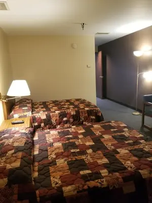 a hotel room with a bed with a quilt on it at Lafayette Inn in Moundsville