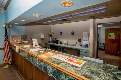 an office with a reception counter with an american flag at Lafayette Inn in Moundsville