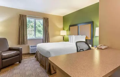 a hotel room with a bed and a chair at Extended Stay America Suites - Fort Wayne - North in Fort Wayne